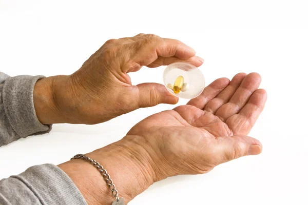 Oudere man giet pillen in hand — Stockfoto