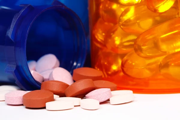 Macro weergave van pil fles morsen een verscheidenheid van pillen — Stockfoto