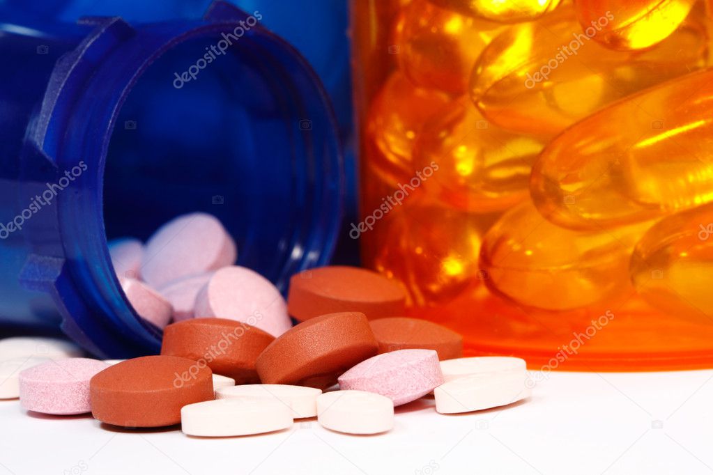 Macro view of pill bottle spilling a variety of pills