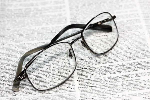 stock image Closeup view of glasses at rest on a dictionary