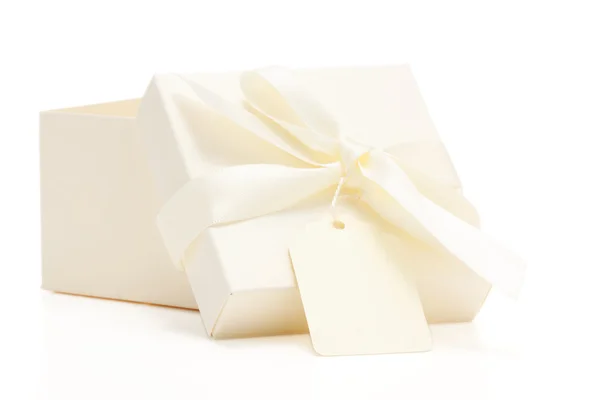 Cream colored gift box with bow and name tag — Stock Photo, Image