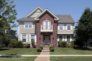 Brick home with front balcony clipart