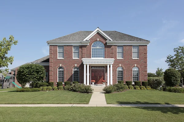 Large brick home with white columns Stock Image