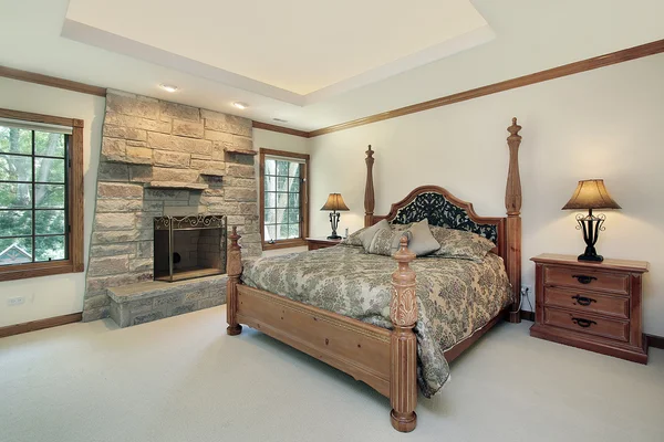 Master bedroom with stone fireplace — Stock Photo, Image