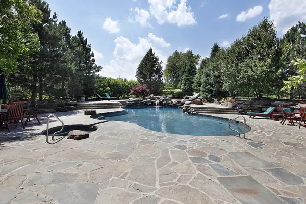 Piscina con gran patio de piedra — Foto de Stock