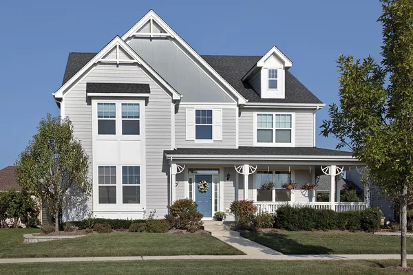 Casa com varanda frontal e porta azul — Fotografia de Stock