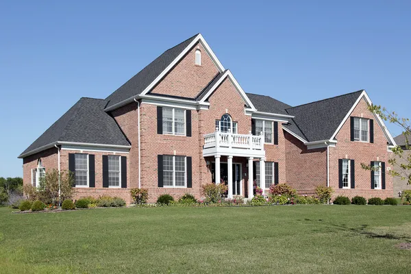 Brick home with white balcony — Stock Photo, Image