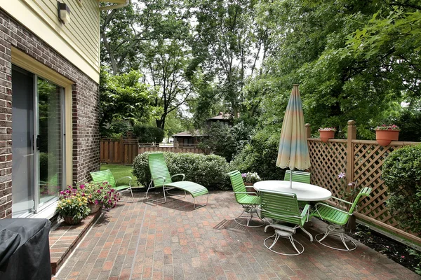 Patio con patio de ladrillo y muebles verdes —  Fotos de Stock