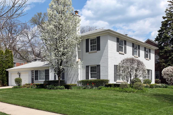 Biały cegła dom na wiosnę — Zdjęcie stockowe