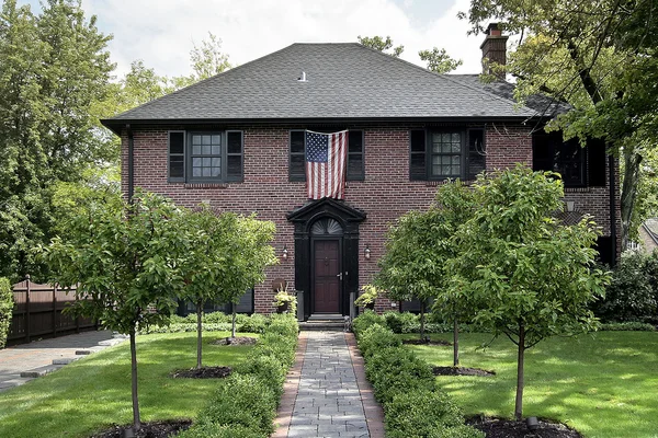 Casa de ladrillo con bandera americana — Foto de Stock