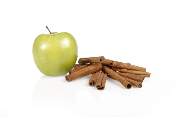 Green apple and cinnamon sticks — Stock Photo, Image