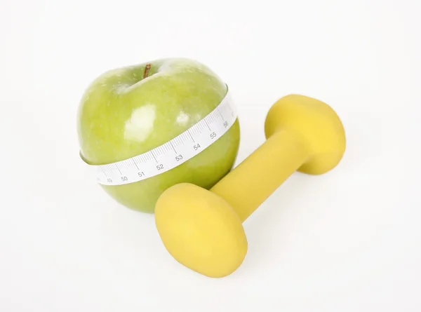 Dumbbell, green apple and measure tape — Stock Photo, Image