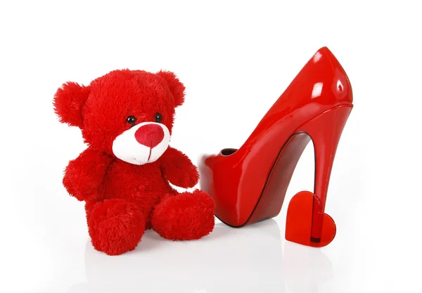 Червоний плюшевий ведмедик, серце і взуття — стокове фото