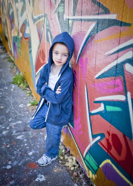 Мальчик против стены граффити — стоковое фото