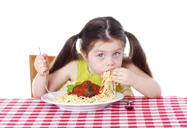 Menina bonita comer macarrão e almôndegas com as mãos Imagens Royalty-Free