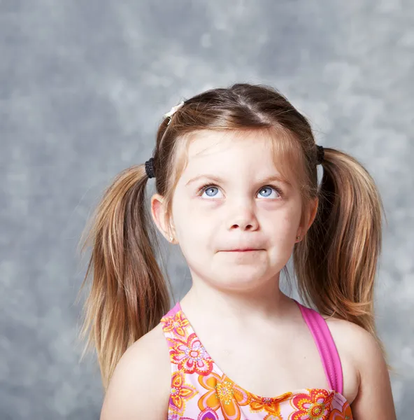 Симпатична маленька дівчинка дивиться в бік копій — стокове фото