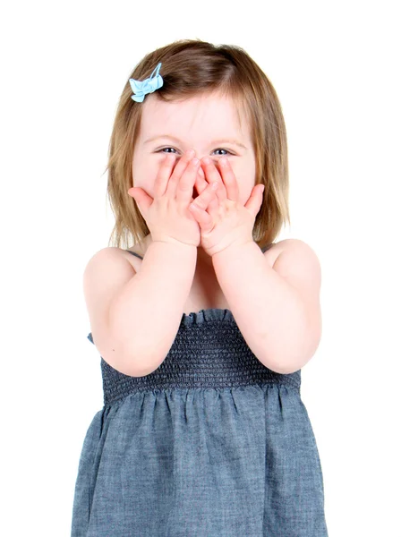 Милая маленькая девочка, держащая руки над ртом — стоковое фото