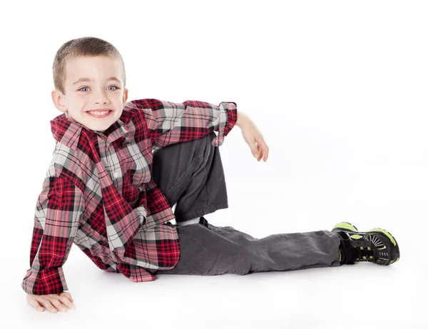 Jeune garçon en chemise à carreaux posée sur le côté en studio — Photo