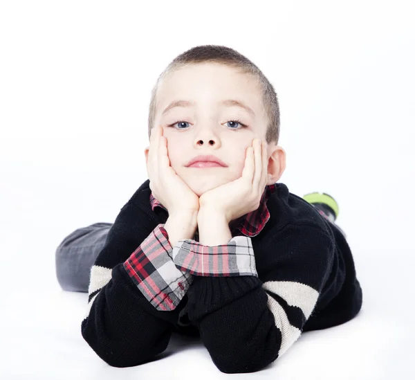 Young boy laying down in studio — Stock Photo, Image