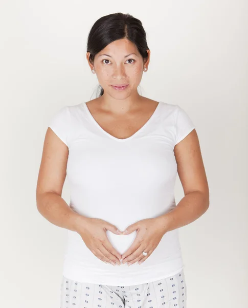 Bastante asiática embarazada haciendo un corazón con sus manos — Foto de Stock