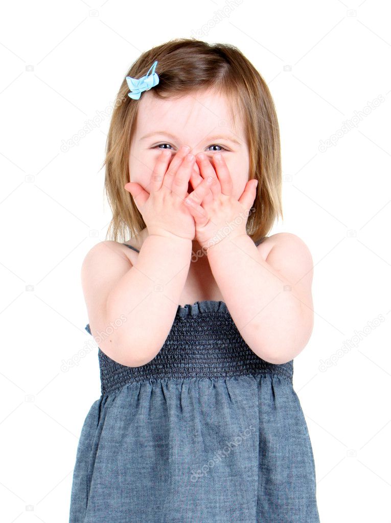 Cute little girl holding her hands over her mouth