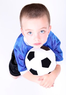 Young preschool boy laying on a soccer ball clipart