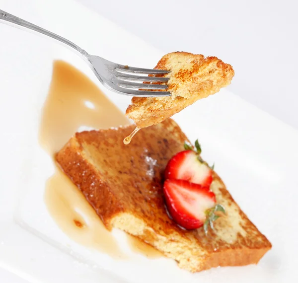 stock image French toast with drip of syrup and strawberries on white backgr