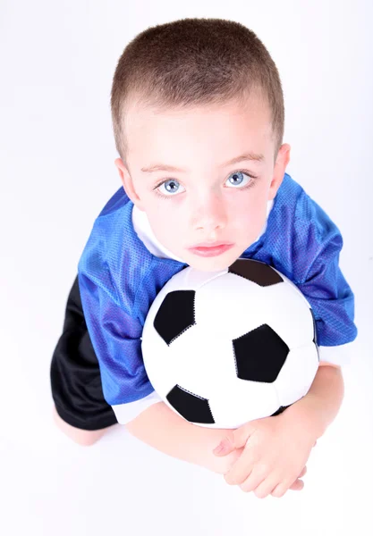 Young preschool boy laying on a soccer ball — Stock Photo, Image