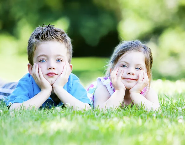 Siblings laying in the grass — Stock Photo, Image