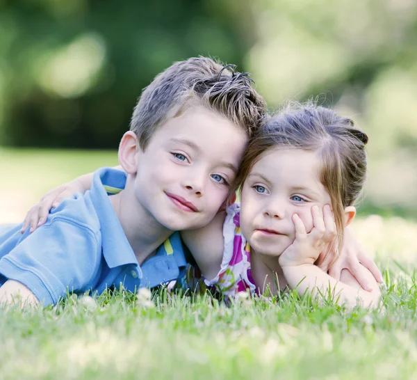 Брат и сестра лежат в траве — стоковое фото