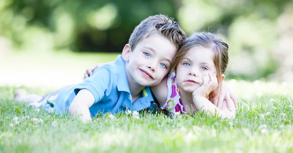 Двоє дітей лежать на траві — стокове фото