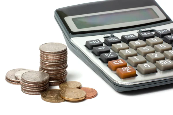 Stos monet i kalkulator na białym tle — Zdjęcie stockowe