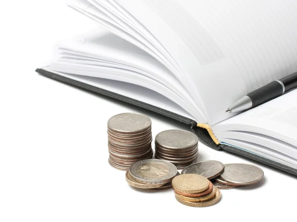 Stacks of coins, diary and pen isolated on white — Stock Photo, Image