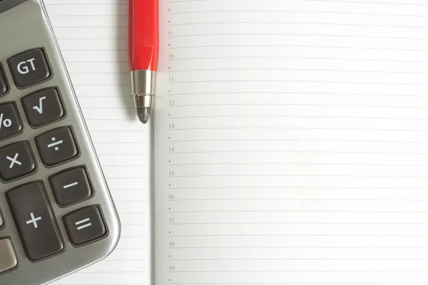 Калькулятор и красная ручка — стоковое фото