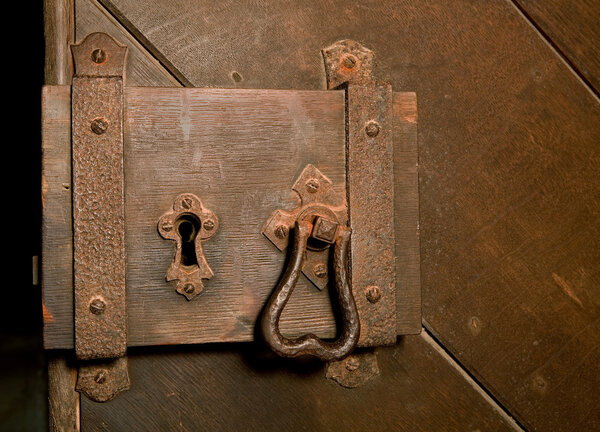Antique rusty lock on a medieval wooden door