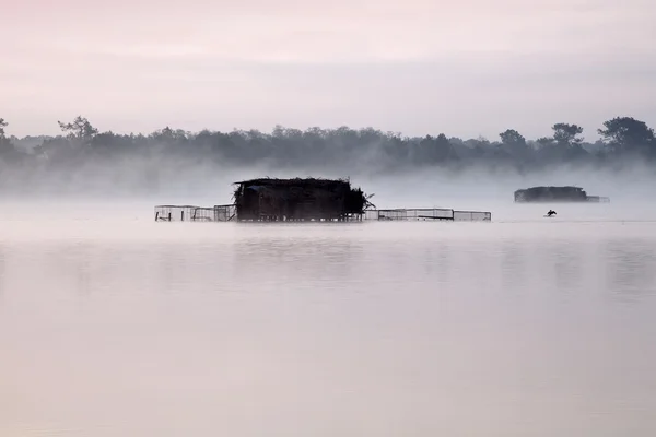Huts on a misty lake — Stock Photo, Image