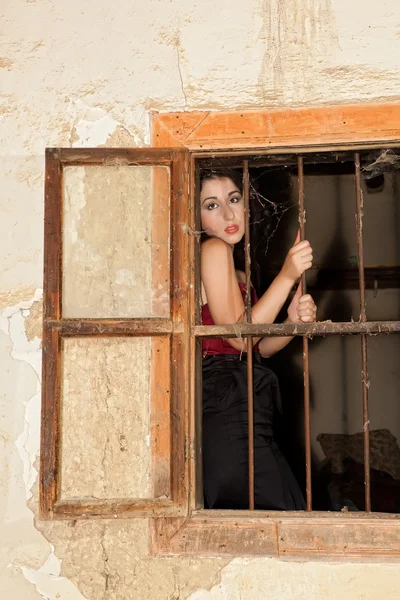 Smutná žena za mřížemi — Stock fotografie