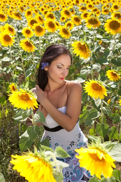 Brown hair and yellow sunflowers — Stock Photo, Image