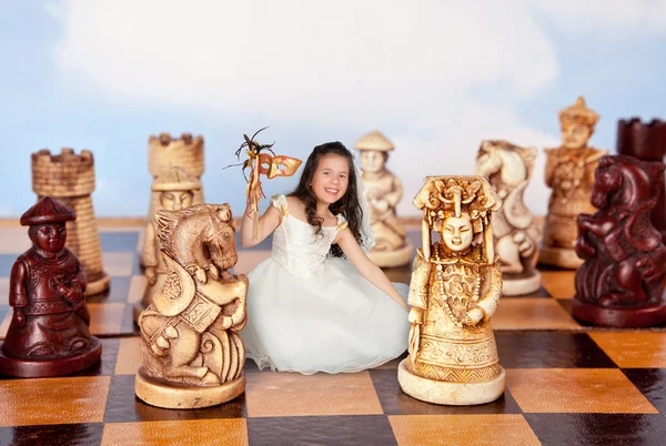Mini girl on chessboard — Stock Photo, Image