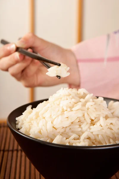 Tomar arroz com pauzinhos — Fotografia de Stock