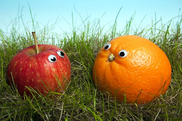 Яблоко и апельсин с улыбающимися глазами — стоковое фото