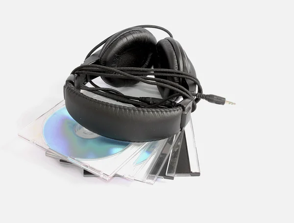 Ακουστικά μεγαλύτερη και μαύρο θέσει σε δίσκους cd σε ένα λευκό φόντο — Φωτογραφία Αρχείου