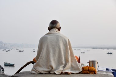 Sadhu praying at the ghats in Varanasi clipart