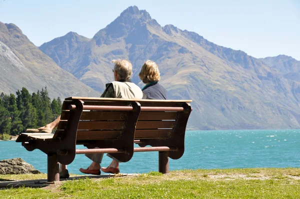 Visão traseira de um casal idoso sentado em um banco de parque — Fotografia de Stock