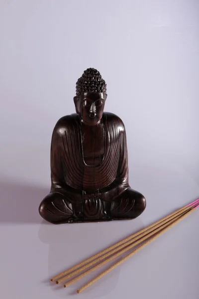 Wooden Buddha meditating with incense — Stock Photo, Image