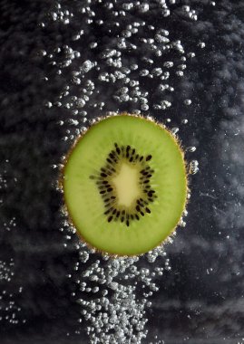 Kiwi and bubbleson a dark background