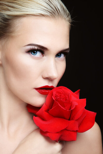 Close-up portrait of young beautiful sexy blond woman with red rose