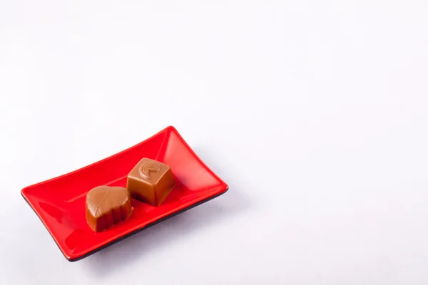 Dvě čokolády na čtvercové desce — Stock fotografie