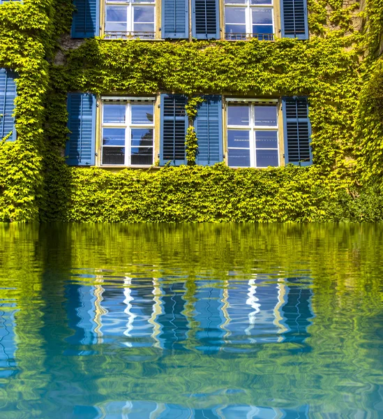 Miljö koncept, gröna hus med reflektion i vatten — Stockfoto