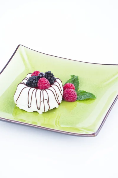 Chocolate blanco y negro con moras en plato verde — Foto de Stock